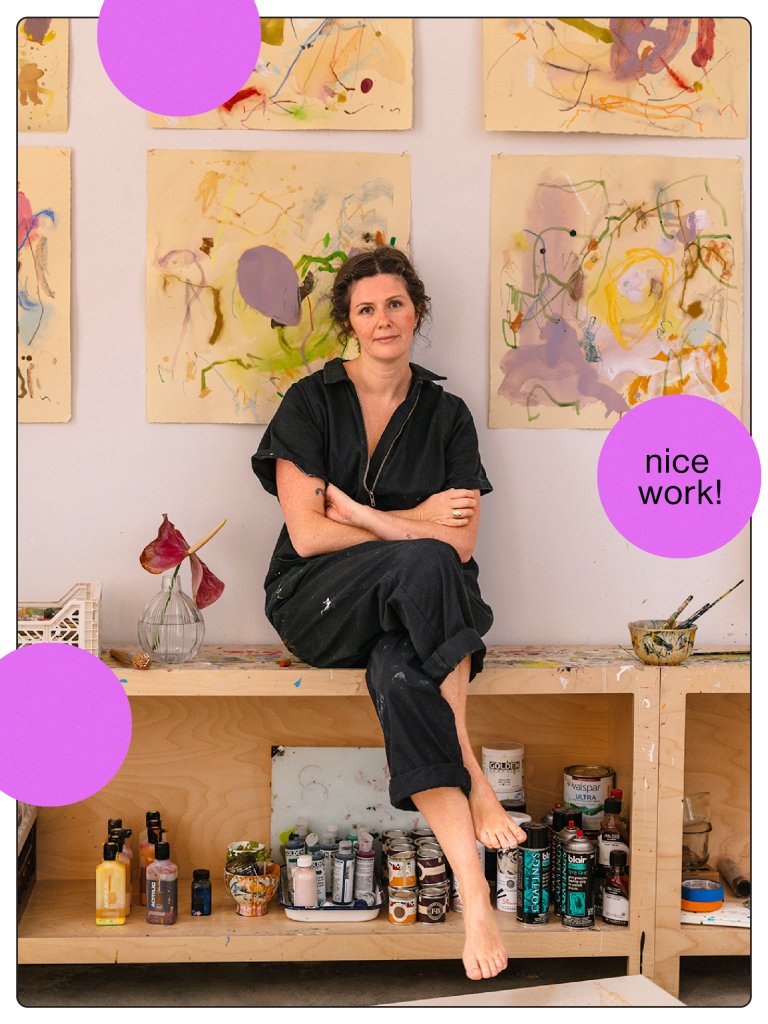 artist sitting on wood shelf with her paintings