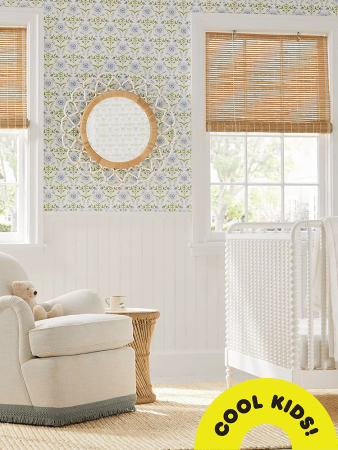 Nursery with bamboo window treatment, white crib, and nursery glider with fringe