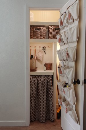 Organized storage closet with cubbies and over the door organizer